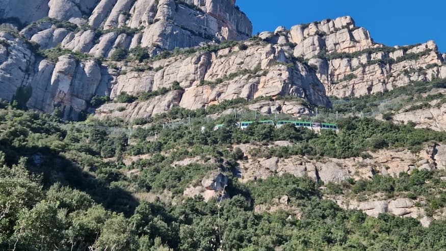 Montserrat rack railway train crossing the mountain slopes below the rocky peaks