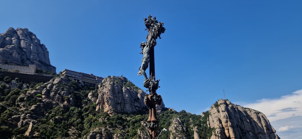 Monumental Rosary sculpture on the Santa Cova path with Montserrat mountains in the background