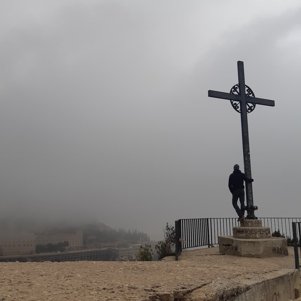 St. Michael’s Cross in Montserrat on a foggy winter morning with the monastery in the background