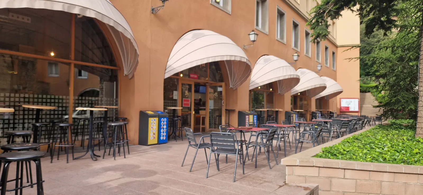 Terrace tables under white awnings at Bar de la Plaça, one of the Montserrat restaurants