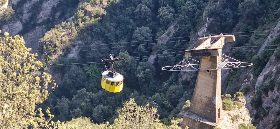 Yellow Aeri de Montserrat cable car cabin passing a pylon