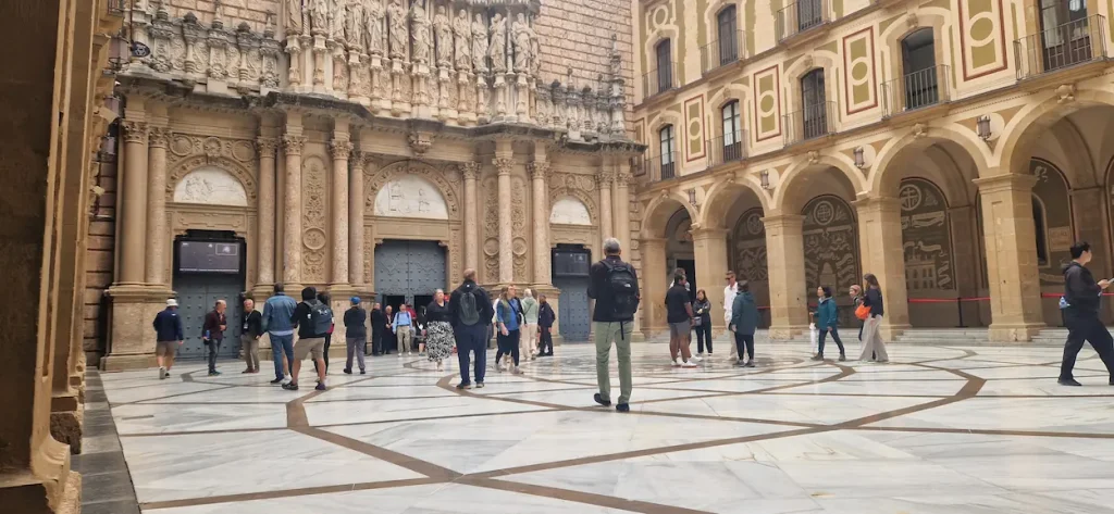 Visiting Montserrat: the Abbot Arguerich atrium and the basilica façade with the twelve apostles